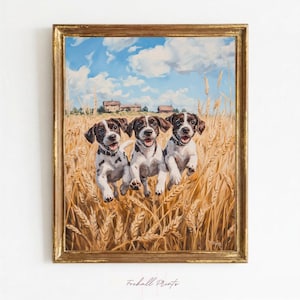 May include: A framed oil painting depicts three brown and white spotted puppies running through a golden wheat field under a bright blue sky with white clouds. In the distance, small rustic buildings are visible. The frame is ornate and gold.