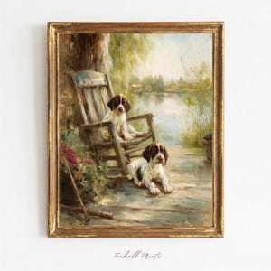 May include: A framed oil painting depicting two brown and white spotted puppies on a wooden deck by a lake. One puppy sits on a wooden chair, while the other lies on the floorboards. The scene includes a cluster of pink flowers and a walking stick.