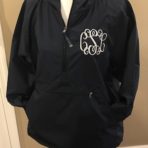 May include: A navy blue hooded jacket with a zipper closure and a white monogrammed "GSL" on the front.