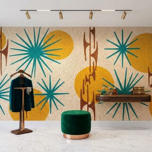 May include: A room interior featuring a wall with a textured pattern of yellow circles and teal starbursts, a dark green velvet ottoman, a wooden valet stand holding a dark blazer, and a floating wooden shelf with glass bottles.
