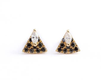 May include: A pair of gold triangle stud earrings with a marquise-shaped clear stone at the top and black stones around the perimeter.