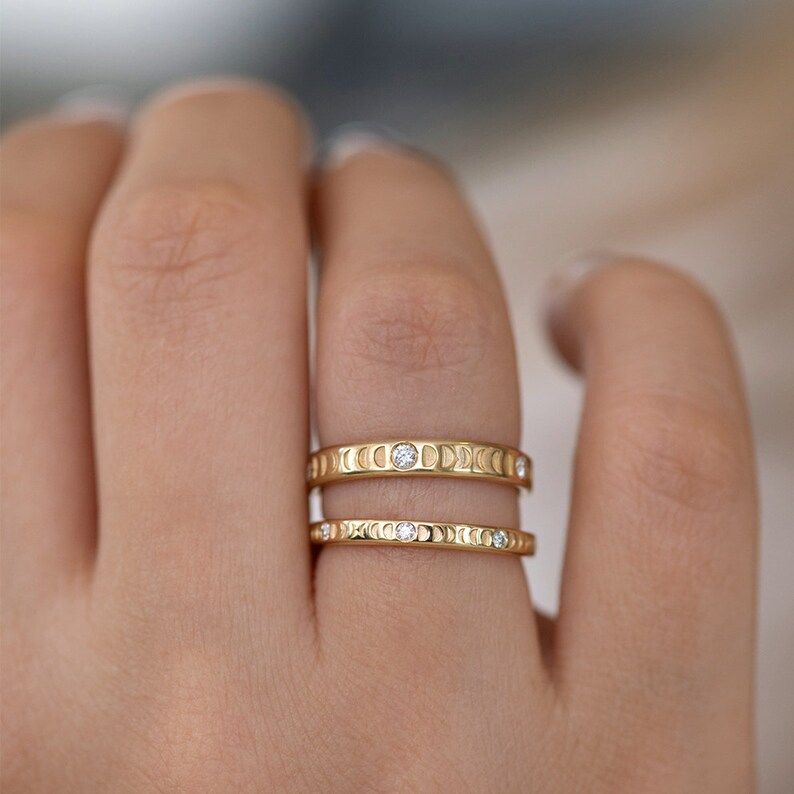 Puede incluir: Dos anillos de oro con un dise&ntilde;o de luna creciente y peque&ntilde;os diamantes engastados en la banda.