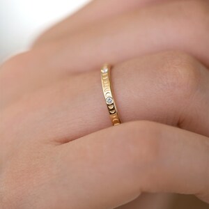 Puede incluir: Un anillo de banda de oro con un delicado dise&ntilde;o de luna creciente y peque&ntilde;os diamantes engastados en la banda.