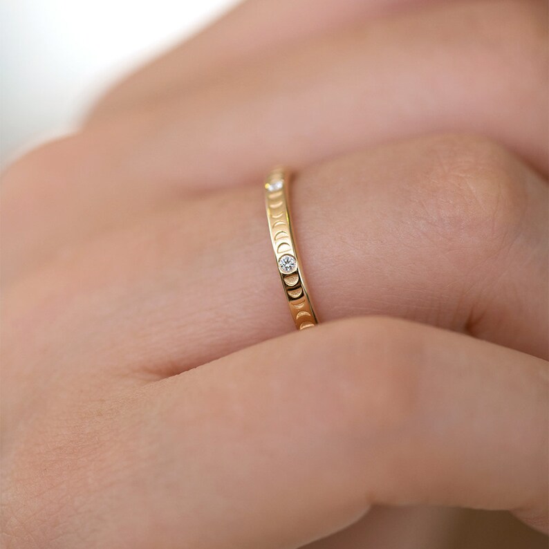 Puede incluir: Un anillo de banda de oro con un delicado dise&ntilde;o de luna creciente y peque&ntilde;os diamantes engastados en la banda.