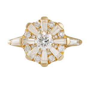 Op de afbeelding: Een gouden ring met een grote ronde centrale diamant omgeven door kleinere diamanten in een stervormig patroon.