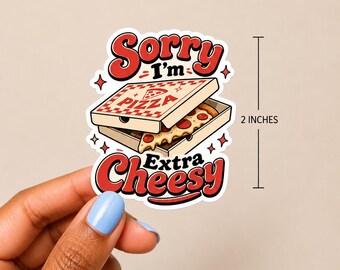 May include: A die-cut sticker featuring a cartoon pizza box with a slice of pepperoni pizza inside. The text reads Sorry I'm Extra Cheesy. The sticker is 2 inches tall as indicated by the adjacent measurement line. The design uses red, white, and tan colors.