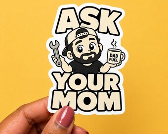 May include: A die-cut sticker featuring a cartoon illustration of a bearded person wearing a baseball cap, holding a silver wrench in one hand and a white mug labeled DAD FUEL in the other, with the bold text ASK YOUR MOM printed in black and cream.