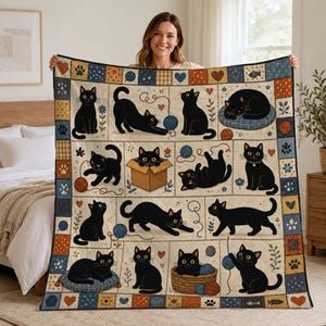 May include: A quilted throw blanket featuring a grid pattern of black cats in various poses, including sitting, playing with yarn, and resting in a box. The border consists of small squares with hearts, paw prints, and fish icons in blue and orange.