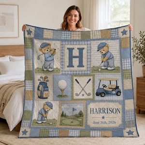 May include: A quilted blanket featuring a golf theme with illustrations of teddy bears in blue outfits, golf clubs, a golf cart, and a golf ball on a tee. The design includes the letter H, the name Harrison, and the date June 26th, 2026.