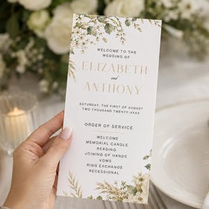 May include: A rectangular wedding programme card featuring white cardstock with a floral and pampas grass border. The text reads: WELCOME TO THE WEDDING OF ELIZABETH and ANTHONY, SATURDAY, THE FIRST OF AUGUST, TWO THOUSAND TWENTY-XXXX, ORDER OF SERVICE.