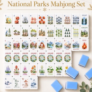 May include: A National Parks Mahjong set featuring white tiles with colorful illustrations of landscapes, flora, and numbered rocks. The set includes Joker tiles, directional tiles labeled E, S, W, N, and several plain blue tiles arranged in a grid.