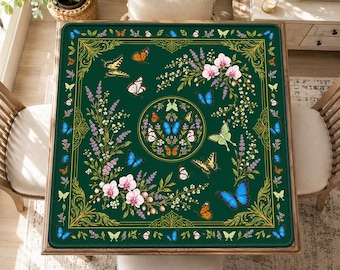 May include: A square dark green tablecloth featuring a central circular medallion surrounded by various colorful butterflies and floral sprays including white orchids and lavender. The border is decorated with gold filigree and small butterflies.