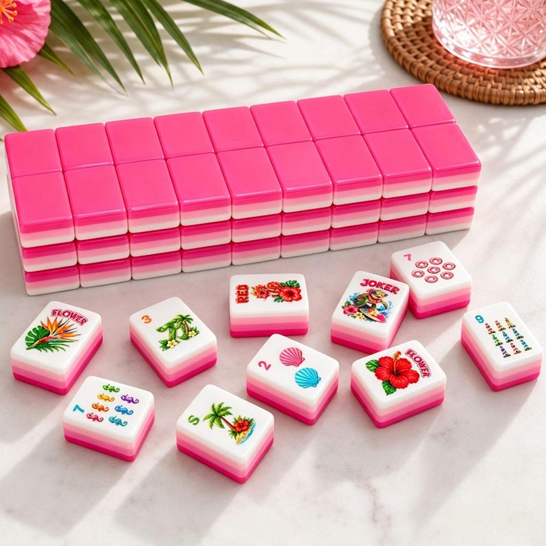 May include: A complete Mahjong set with pink and white tiles. The set includes tiles with various symbols, numbers, and tropical-themed illustrations. The tiles are stacked and arranged on a marble surface, ready for play.