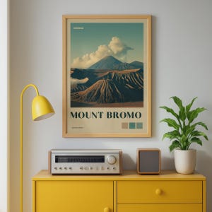 May include: A framed vertical wall art print featuring a landscape of Mount Bromo in Indonesia. The poster displays the text Mount Bromo, Indonesia, and East Java, with a color palette of tan, teal, and dark green squares at the bottom.
