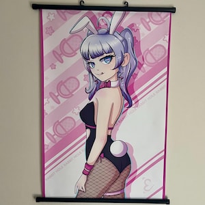 May include: A wall scroll featuring an anime-style character with purple hair and white rabbit ears. The character wears a black bodysuit, pink collar, and fishnet stockings. The background is pink with diagonal stripes, microphone icons, and the text RABBIT HOLE.
