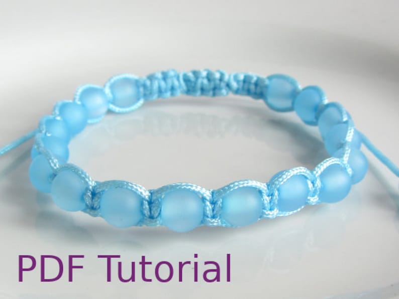Close up of light blue beaded macrame square knot bracelet with slider closure. With PDF Tutorial written on the image.