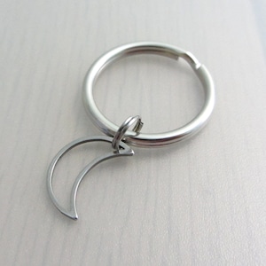 May include: A silver key chain with a crescent moon charm.