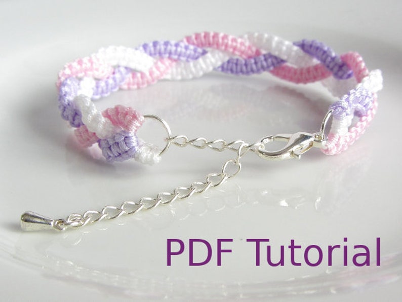 A bracelet that has a 3 braid effect. Each braid is made using square knots and each braid is in a separate colour - white, lilac and pink. With a close up of the metal chain and clasp closure. With PDF Tutorial written on the image.