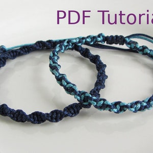 Könnte beinhalten: Zwei geflochtene Armbänder, eines dunkelblau und eines hellblau mit Schimmer, werden auf einer weißen Oberfläche gezeigt. Der Text "PDF Tutorial" wird über den Armbändern angezeigt.