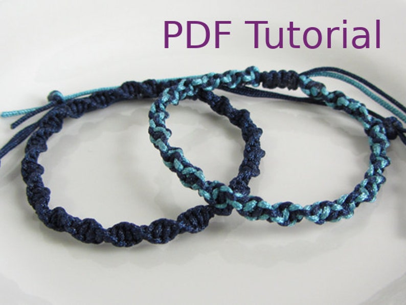 Two macrame half square knot bracelets with slider closures shown laid on top of each other. The bottom bracelet in navy blue cord and the top one with light blue and navy blue cord. With PDF Tutorial written on the image.