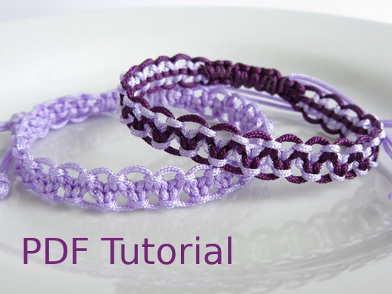 Two macrame alternating square knot bracelets with slider closures shown laid on top of each other. The bottom bracelet in lilac cord and the top one with purple and lilac cord. With PDF Tutorial written on the image.