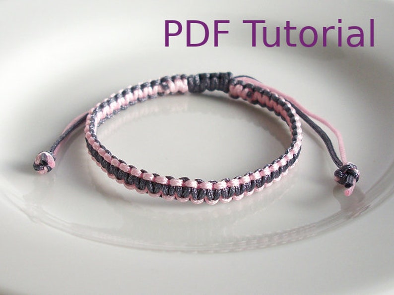 Grey and pink macrame square knot bracelet. The grey cord creates a horizontal colour with pink at the outer edges, and with a grey slider closure. With PDF Tutorial written on the image.