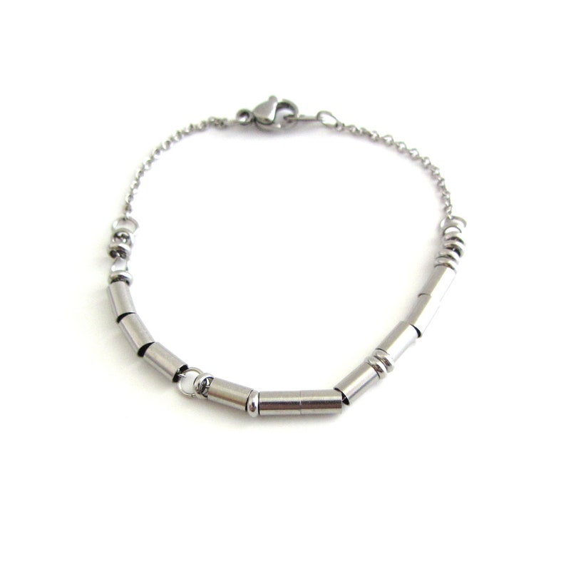 A stainless steel I am enough Morse Code bracelet (thin round and cylinder beads spell out the message) with a fine cable chain and lobster claw clasp.