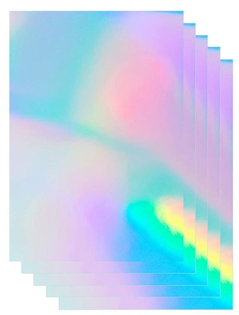 May include: A stack of five rectangular sheets featuring a smooth, iridescent finish. The surface displays a shifting spectrum of pastel colors, including light blue, soft pink, lavender, and hints of yellow, creating a reflective holographic effect.