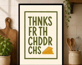 Puede incluir: Una lámina decorativa rectangular en un marco negro con fondo crema y borde verde oscuro. El texto THNKS FR TH CHDDR CHS aparece en letras verde oscuro, acompañado por un pequeño trozo triangular de queso cheddar de color amarillo.