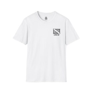 May include: White crew neck t-shirt with a small black and white graphic on the upper left chest. The graphic is a diving flag with the word "CREW" below it. A small emblem is on the upper back of the shirt.