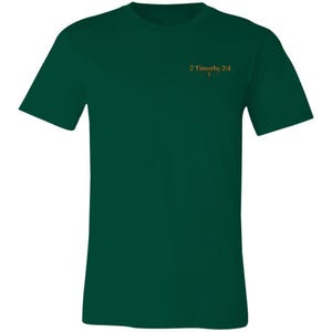 Op de afbeelding: Een donker bosgroen T-shirt met korte mouwen en de tekst 2 Timothy 2:4 in een goudkleurig lettertype op de linkerborst. Het ontwerp bevat een klein kruissymbool dat direct onder de bijbelverwijzing is geplaatst.