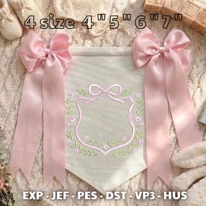 May include: A cream-colored fabric banner featuring an embroidered pink shield outline surrounded by a floral wreath. Two large pink satin bows are attached to the top corners. Text reads 4 size 4 inch 5 inch 6 inch 7 inch and EXP JEF PES DST VP3 HUS.