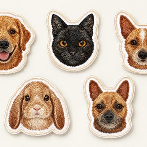 May include: Five embroidered patches featuring animal faces: a golden retriever, a black cat with orange eyes, a brown and white cattle dog, a brown lop-eared rabbit, and a brown short-haired dog. Each patch has a cream-colored stitched border.