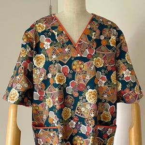 Uniforme médico femenino con cuello en V y dos bolsillos, confeccionado a medida para profesionales de la salud. Blusa médica japonesa de tela floral verde. Tallas de la XS a la XXL. imagen 1