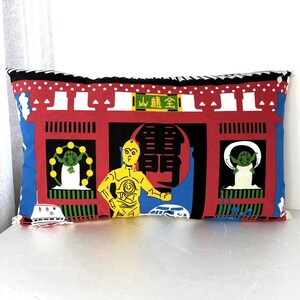 May include: A rectangular throw pillow featuring a vibrant graphic print of a red Japanese temple gate. The design includes a yellow C-3PO figure, two green Yoda characters, and a white R2-D2 droid. The text on the gate includes the characters 全龍山 and 雷門.