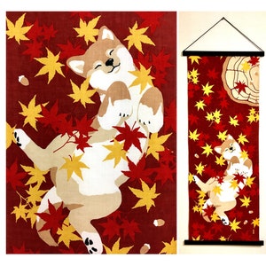 May include: A vertical fabric wall hanging featuring a tan and white Shiba Inu dog lying on its back amidst a scattering of red and yellow maple leaves on a deep red background. The design includes a tree stump graphic and a black hanging rod.
