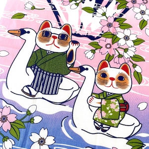 May include: A fabric print featuring two white cats wearing green kimono-style garments, each riding a white swan on a gradient background of pink and blue. The scene is decorated with pink and white cherry blossoms and stylized water ripples.