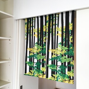 May include: A white curtain with a black and green forest print. The curtain is hanging from a white track.