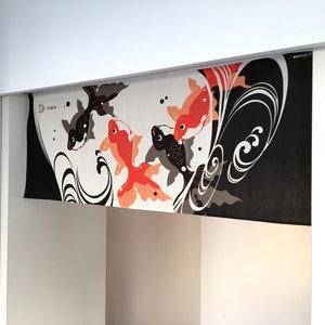 May include: A black and white fabric panel with a design of orange and black fish swimming in a stylized wave pattern. The fabric is hanging from a white ceiling.