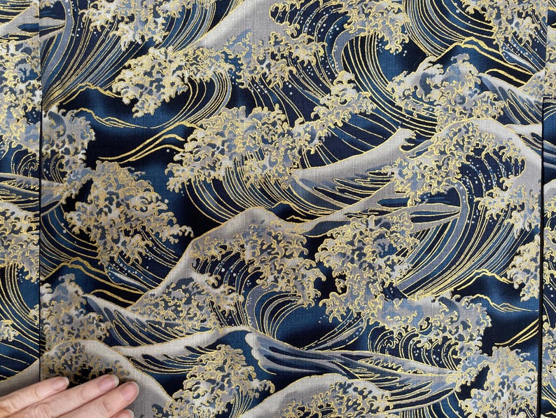 May include: A blue and gold fabric with a repeating pattern of stylized waves. The waves are outlined in gold and have a textured appearance.