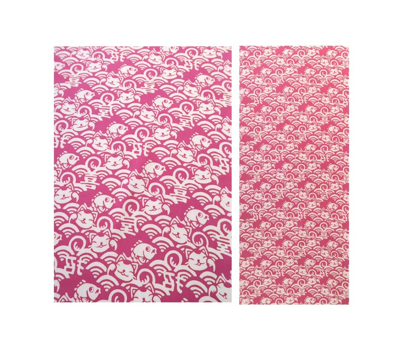 Pu&ograve; includere: Un pannello di tessuto rettangolare con un motivo ripetuto di gatti portafortuna bianchi, pesci e onde stilizzate su uno sfondo magenta vibrante. Il design include piccoli caratteri kanji integrati nei motivi a onda sulla superficie.