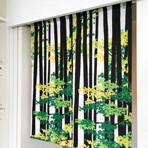 May include: A white fabric panel with a black and green forest print. The print features stylized trees with green and yellow leaves.