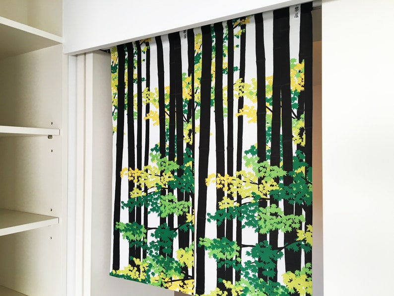 May include: A white fabric panel with a black and green forest print. The print features stylized trees with green and yellow leaves.