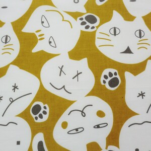 May include: A mustard yellow fabric with a white repeating pattern of cat faces and other abstract designs. The cat faces have different expressions, including happy, sad, and surprised. Some of the designs include paw prints and stars.