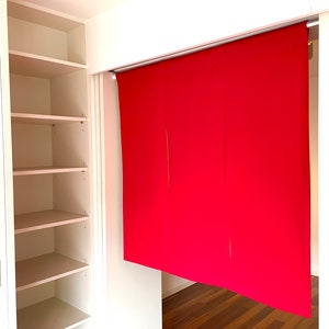 May include: A white closet with four shelves, open and empty. A red fabric room divider is partially visible in the background.