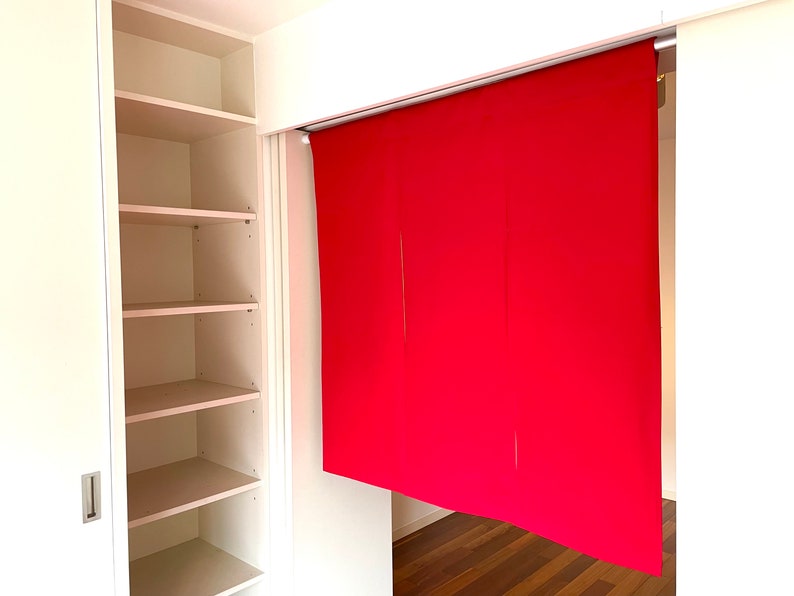 May include: A white closet with four shelves, open and empty. A red fabric room divider is partially visible in the background.