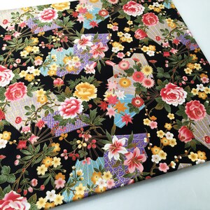 Puede incluir: Tela negra con un patr&oacute;n floral que presenta flores rosas, amarillas y blancas, detalles dorados y un dise&ntilde;o geom&eacute;trico.