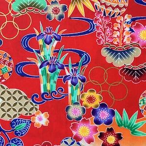 May include: Red fabric with a colorful Japanese-inspired pattern. The pattern features flowers, leaves, and geometric shapes. The fabric is perfect for quilting, sewing, or crafting.