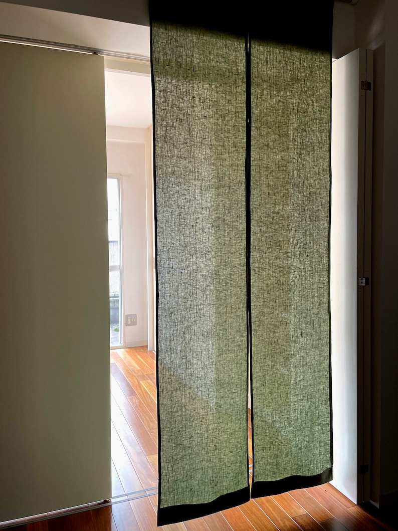 Puede incluir: Dos separadores de ambiente de lino verde oscuro cuelgan de una v&iacute;a en una puerta. Los separadores est&aacute;n hechos de una tela texturizada y tienen un ribete negro.