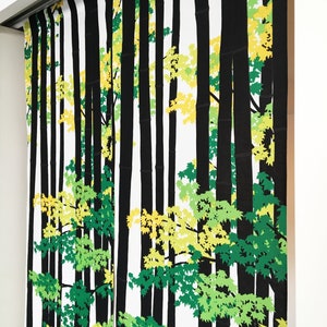 May include: Black and white fabric with a repeating pattern of trees and leaves. The leaves are green and yellow.